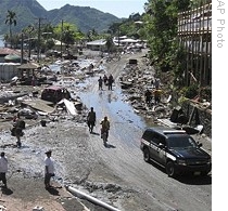 People walk along scene of devastation following powerful quake in Pago Pago village on American Samoa, 30 Sep 2009