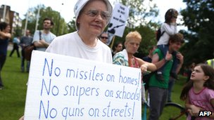 A resident holds a protest banner 