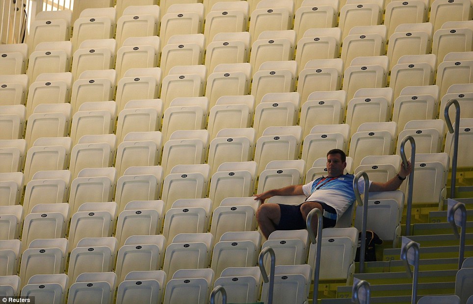 All by myself: A spectator sits among empty seats as he waits for the start of the final session on the first day of the swimming competition at the Aquatics Centre