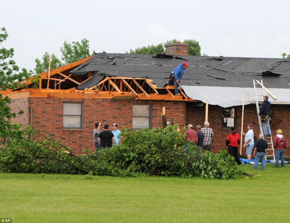 Blown away: Friends and neighbors help out a resident in Lyon County after a tornado ripped the roof off a home just south of Emporia, Kansas