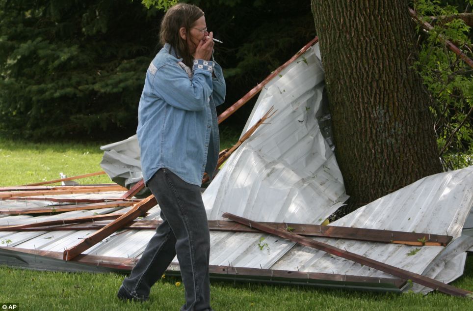 Picking up the pieces: June McFarland reacts to the first sight of storm damage in rural Osage, Iowa after the powerful weather system moved through the area