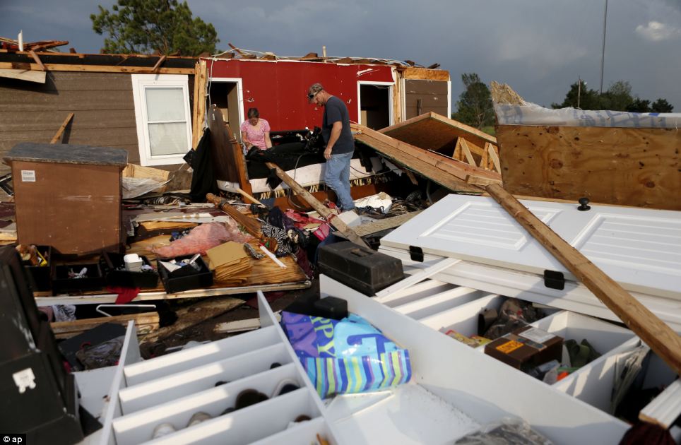Recovery: Nancy and Jason Townsend sort through belongings after their home was hit by a tornado in Carney, Oklahoma