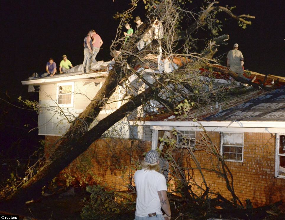 Rallying around: Residents help repair the roof of their neighbour's house which was damaged by a fallen tree in Shawnee