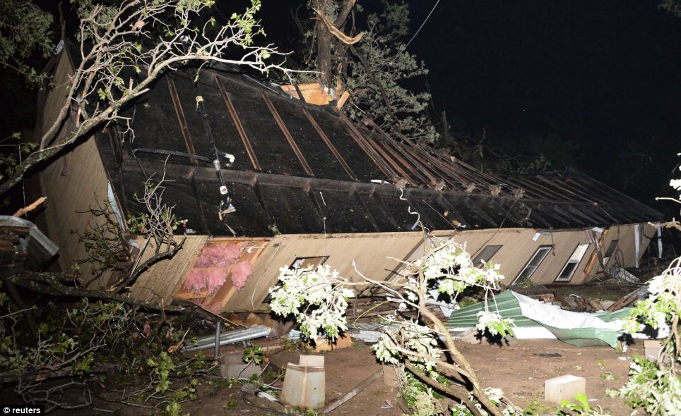 Overturned: A damaged mobile home is pictured amid the debris after a tornado swept through Shawnee