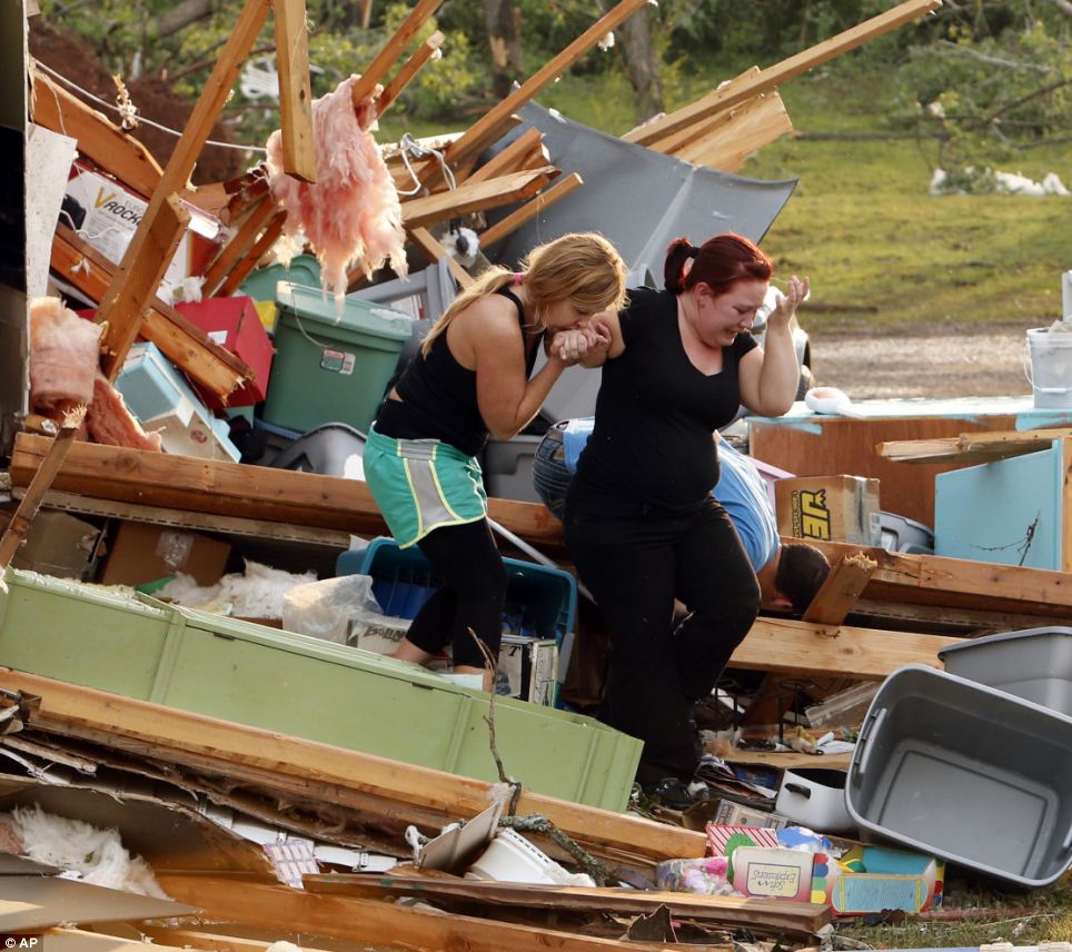 Emotional: Alli Christian, left, helps Jessica Wilkinson as she looks for her dog Bella after Wilkinson returned to find her home in Norman, Oklahoma destroyed by a tornado on Sunday