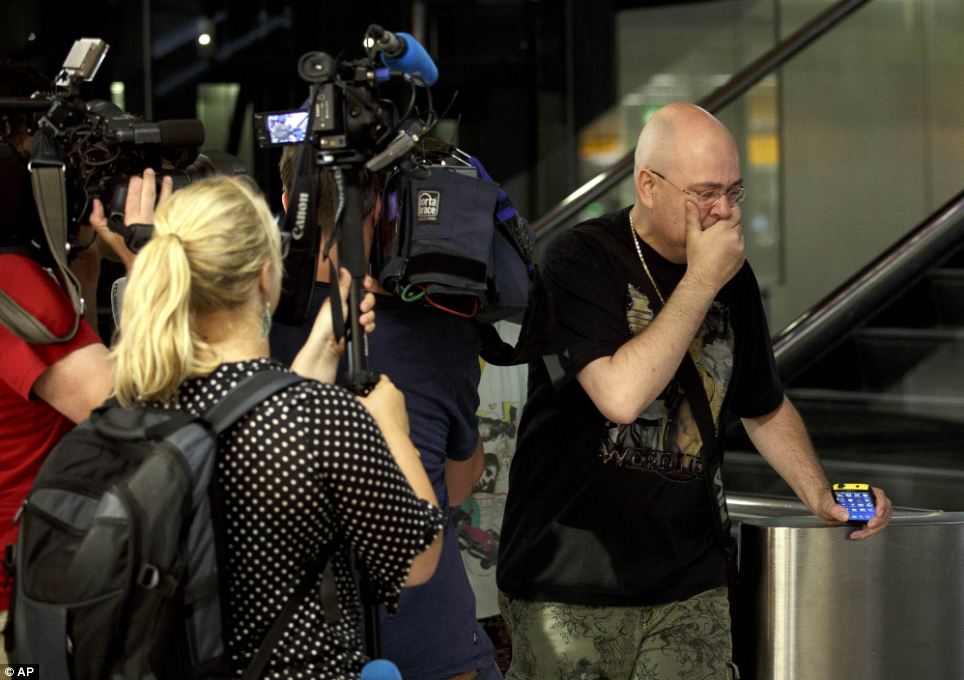 Fear: A relative of one suspected victim walks arrives at Schiphol airport in Amsterdam tonight