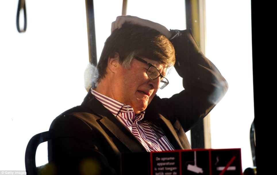 Loss: A relative struggles to contain his emotion as family members of the victims are taken away from Schiphol airport in a special bus tonight