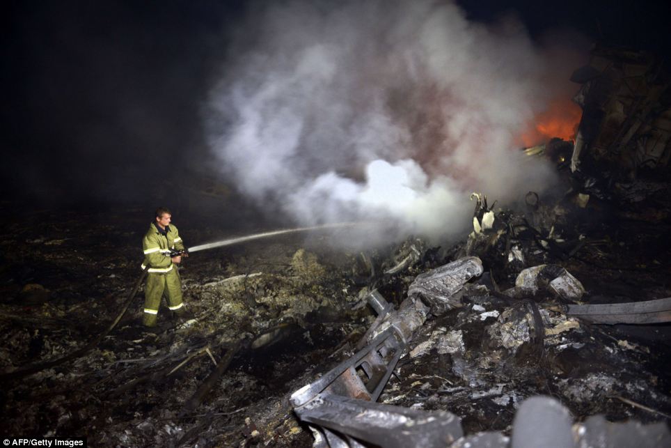 Struggle: A firefighter sprays water on the flames in an attempt to extinguish the fire