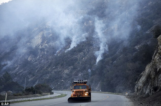 Working around the clock: A truck clears away rocks along San Gabriel Canyon Road as firefighters continue to battle the Colby Fire that was sparked Thursday morning